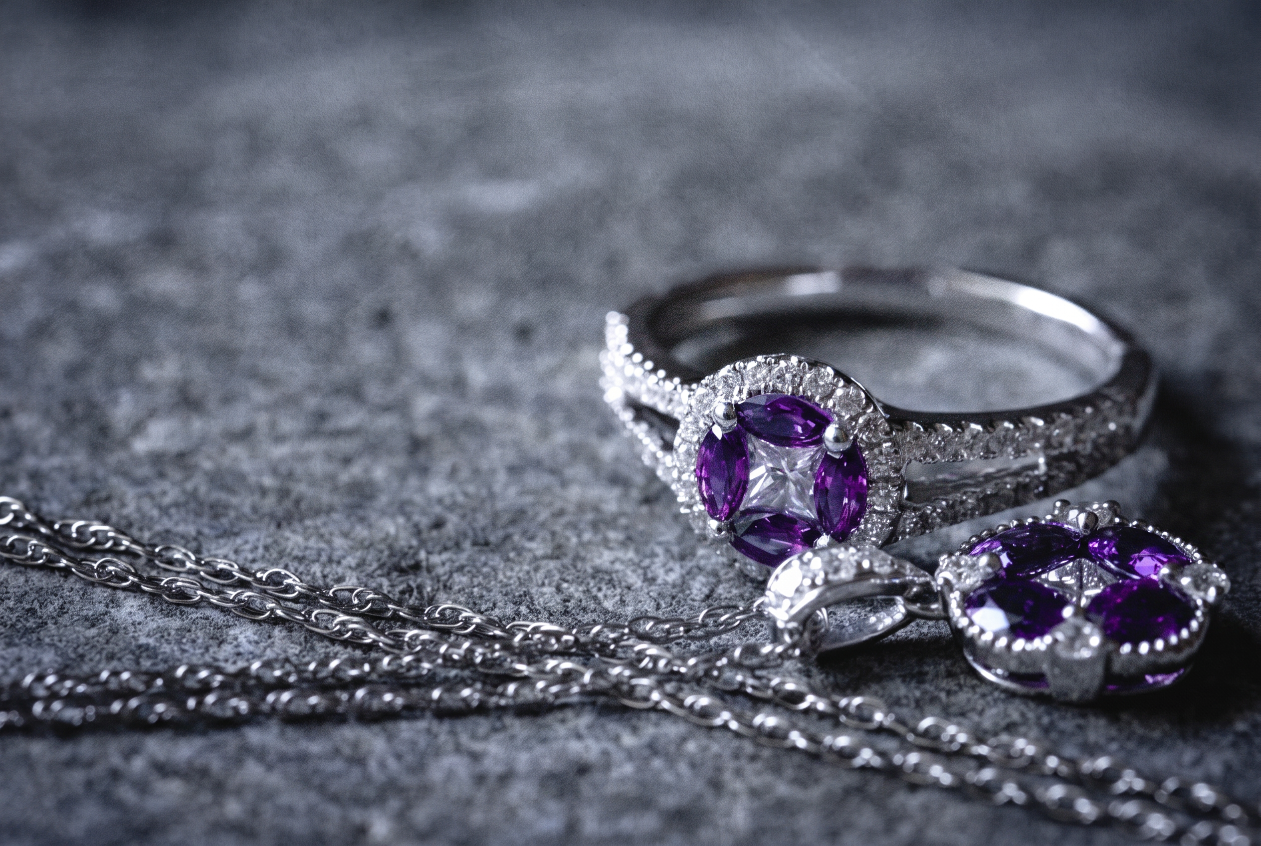 Sapphire and diamond ring with matching pendant necklace on dark stone